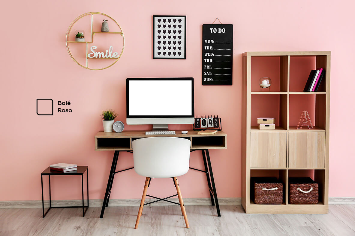 Home office renovado com a cor Balé Rosa da Tintas Coral. A tonalidade rosada trouxe muito mais elegância para esse espaço e super combinou com os móveis de madeira.