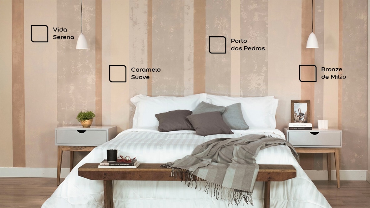 Parede do quarto de casal renovada com o padrão de listras envelhecidas. As cores utilizadas são Vida Serena, Caramelo Suave, Porto das Pedras e Bronze de Milão da Tintas Coral. 