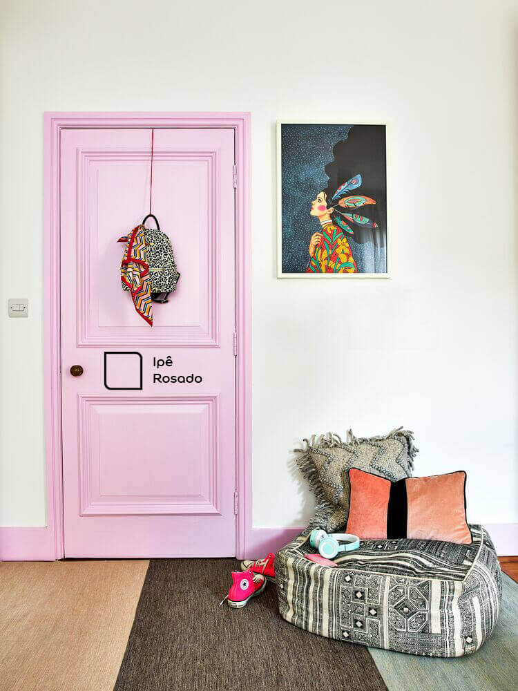 Porta do corredor pintada com a cor Ipê Rosado da Tintas Coral. O rosa da porta super combinou com os móveis em cinza. 