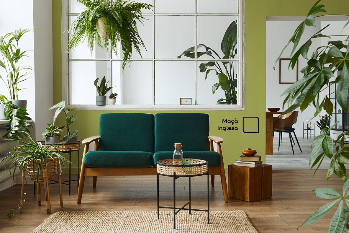 Sala de estar renovada com a cor Maçã Inglesa da Tintas Coral. O tom de verde da parede é perfeito para ambientes com marrom e muito verde natural