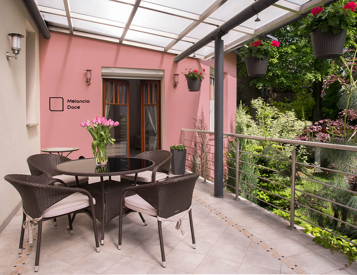 Varanda Gourmet renovada com a cor Melancia Doce da Tintas Coral. Esse tom de rosa, proporciona a sensação de harmonia combinado com as cores dos móveis mais escuras e a vegetação  
