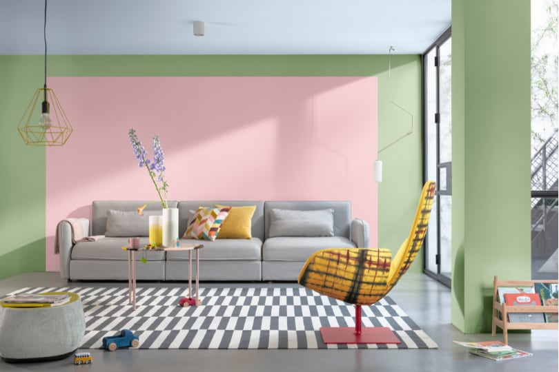 Sala com parede pintata com um retangulo rosa e o restante em verde