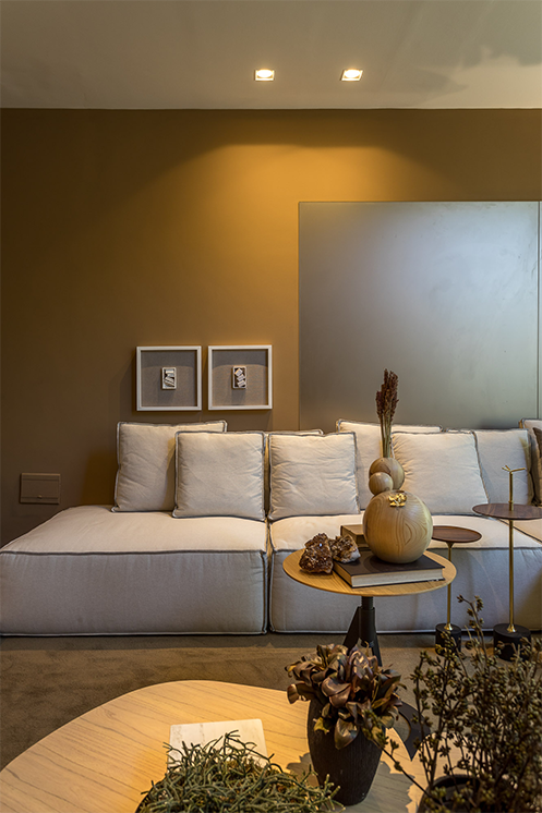 Sala decorada com sofá combinando com a cor da parede.
