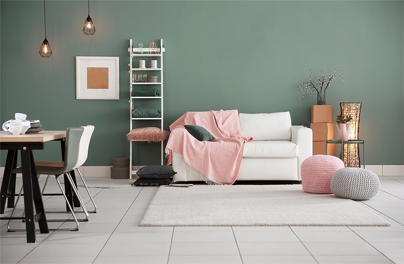 Sala decorada com sofá combinando com a cor da parede.