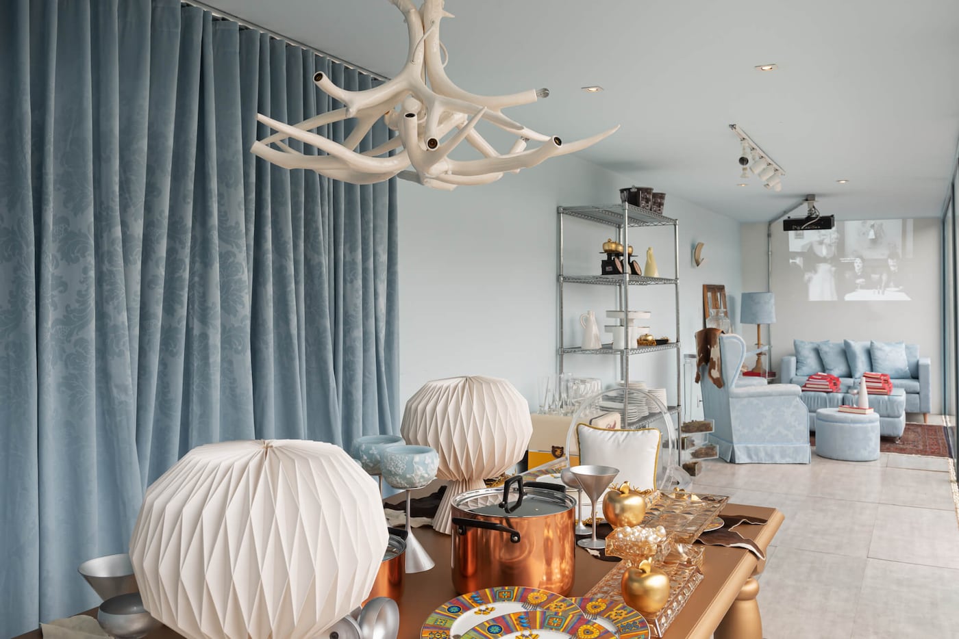 Sala integrada decorada com parede em tons de azul.