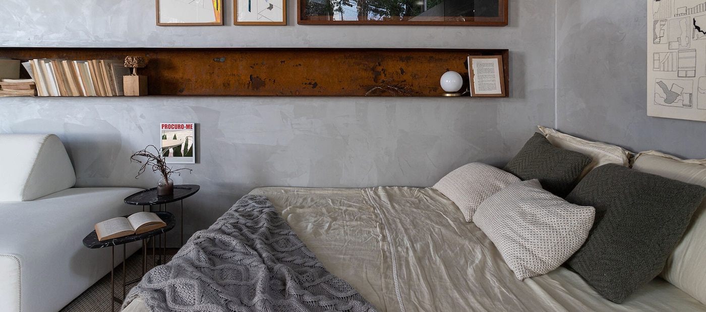 Quarto decorado com parede em tons de cinza.