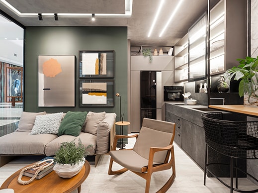 Sala integrada com cozinha decorada com parede em tons de cinza.