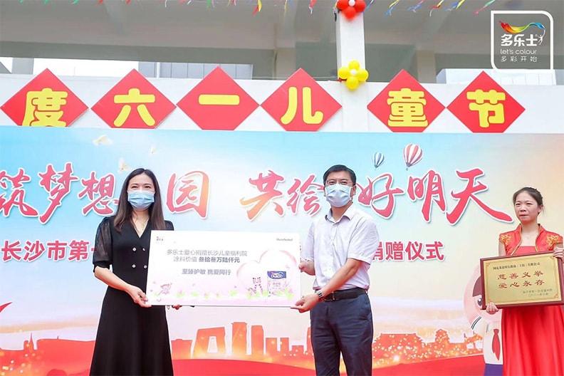 长沙市儿童福利院院长龙环和阿克苏诺贝尔装饰漆中国及北亚事业部技术总监陈玲 互赠捐赠匾额