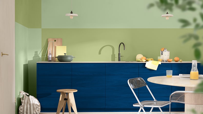 Kitchen with blue cabinets and green block colour walls