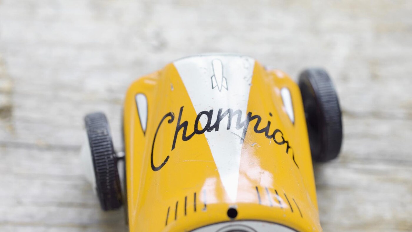 Yellow toy car, speeding towards the finish line.