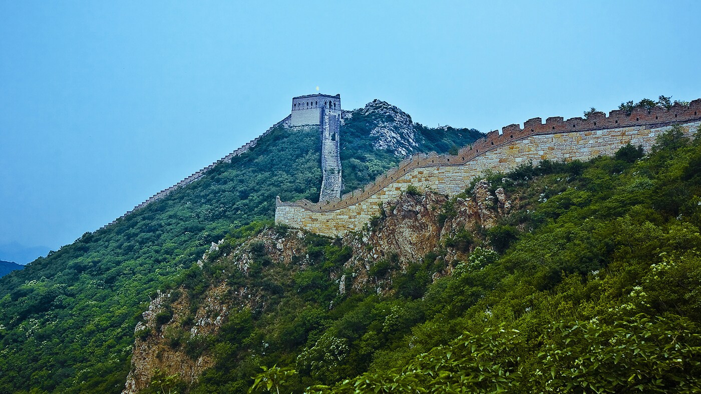Great Wall of China looks magnificent against a blue and green landscape.