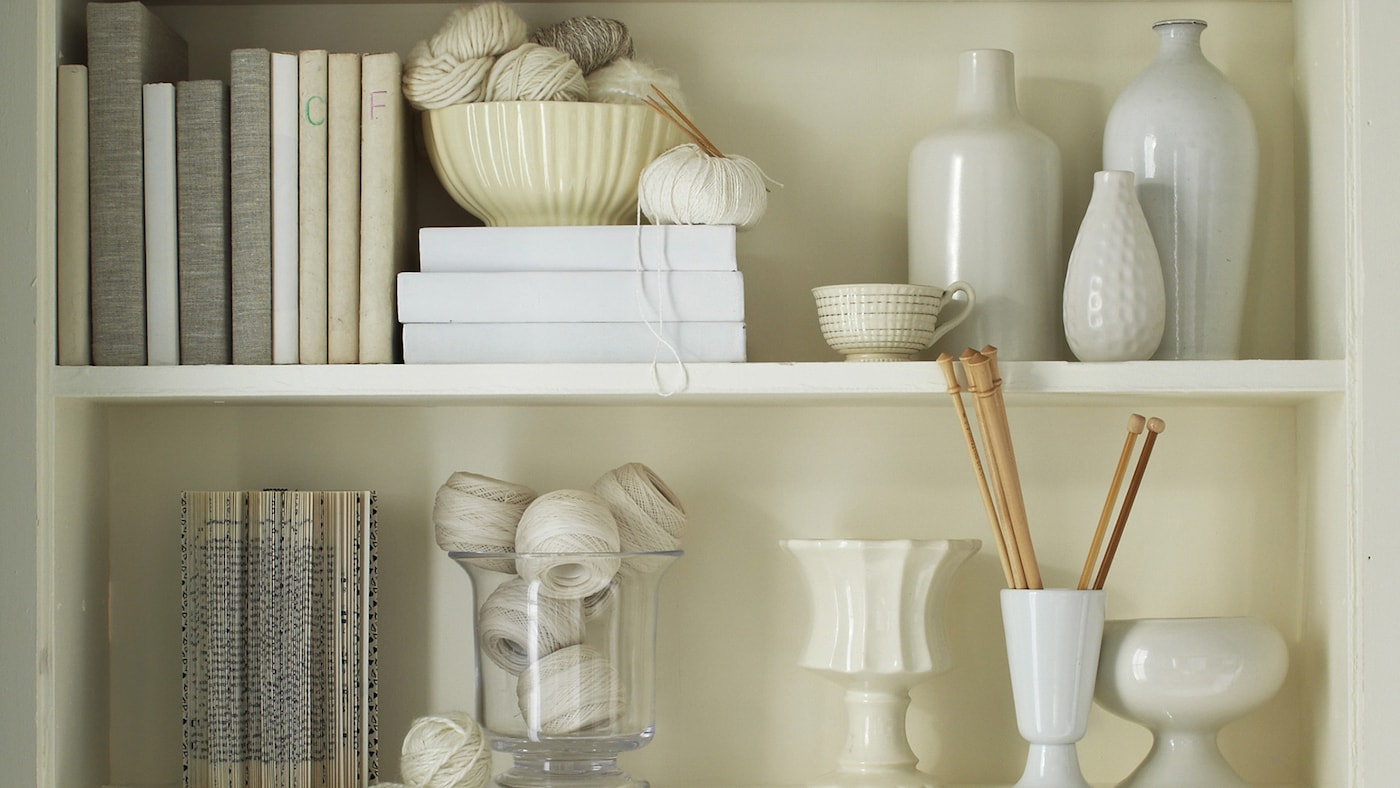 Bookshelves filled with vases, books and precious mementos in beautiful shades of white and off-white. 