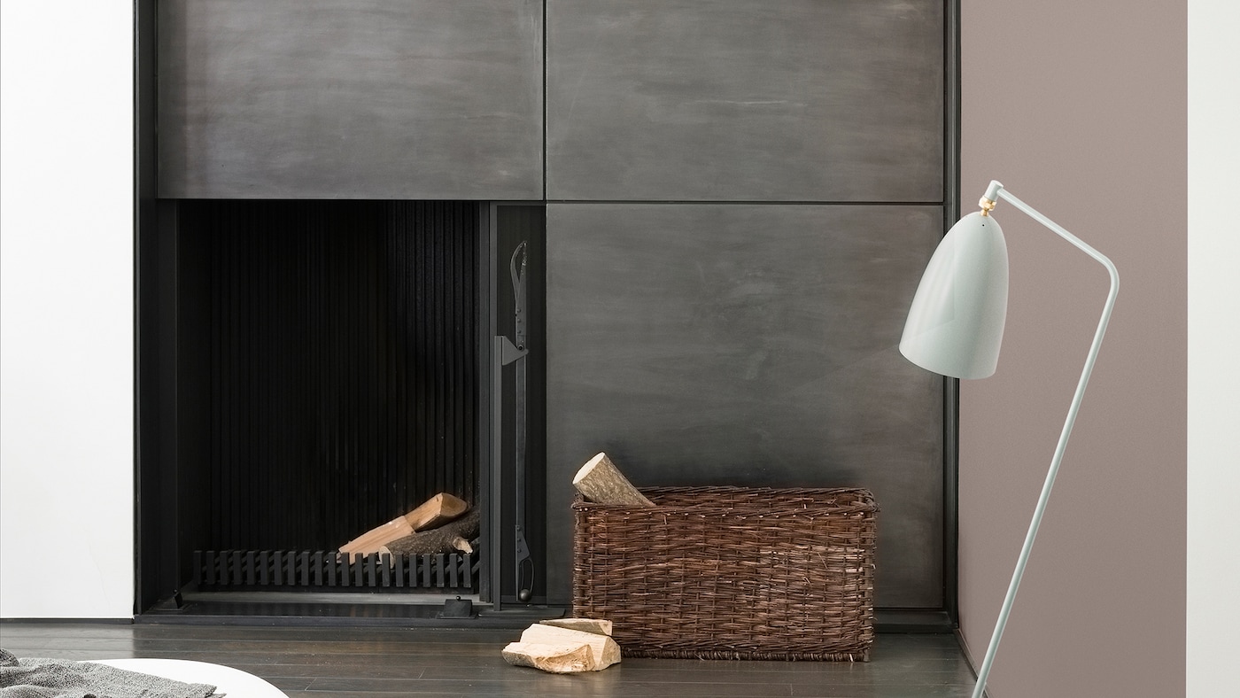 Enhance a minimalist metal fireplace with warm, rich neutrals like dove grey and charcoal.