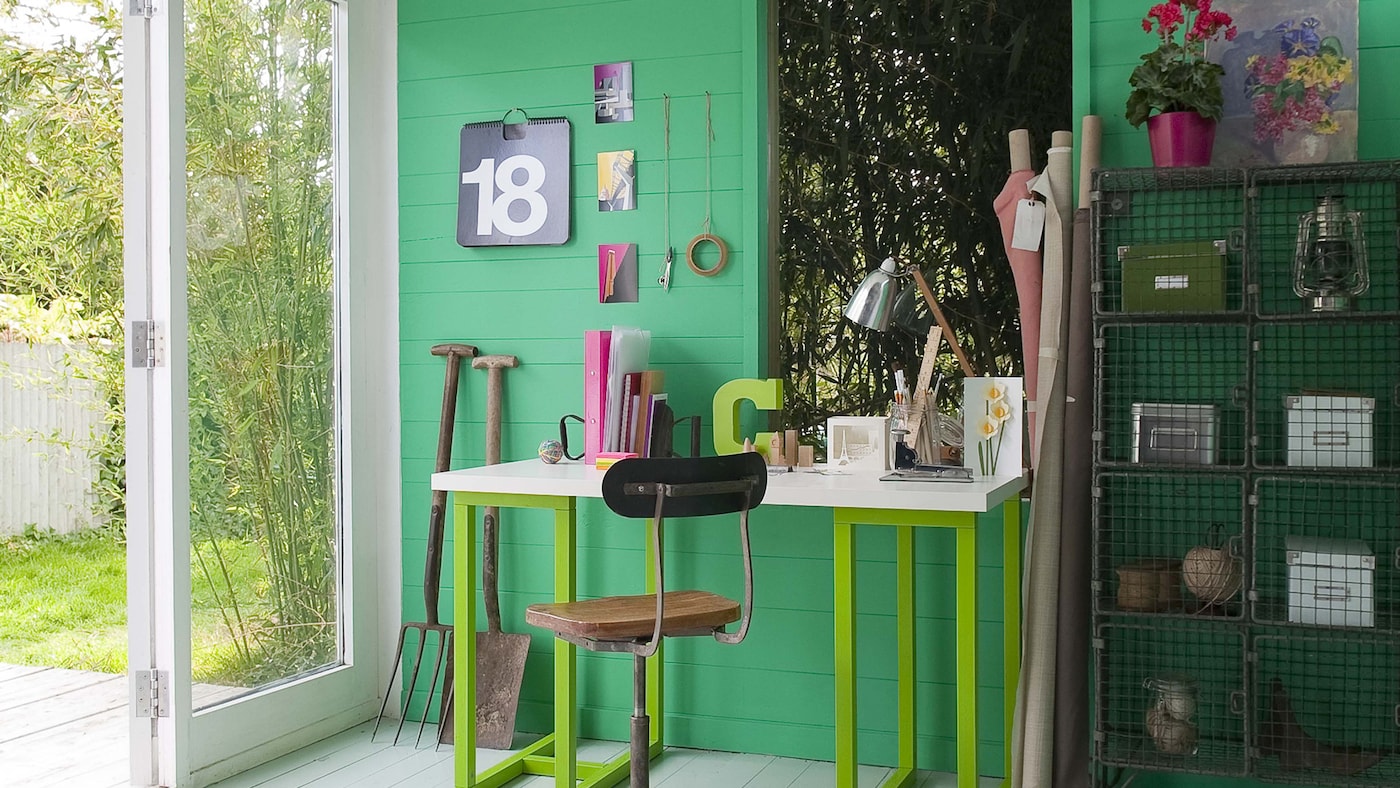 Study painted in various shades of green features a work space and a storage area.