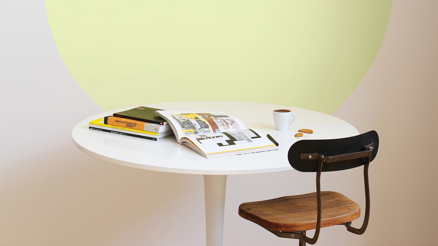 A yellow circle adds fun and colour to a white dining space.
