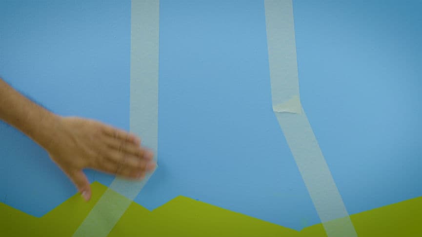 Taśmą malarską wyklej kontury drzewa w pokoju trolla. 