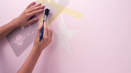 Za pomocą szablonów malarskich lub taśmy malarskiej narysuj gwiazdki i wypełnij je farbą Dulux EasyCare
