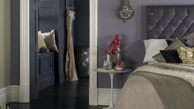 Wpadające przez okno promienie słoneczne rozświetlą ściany fioletowo-szarego pokoju