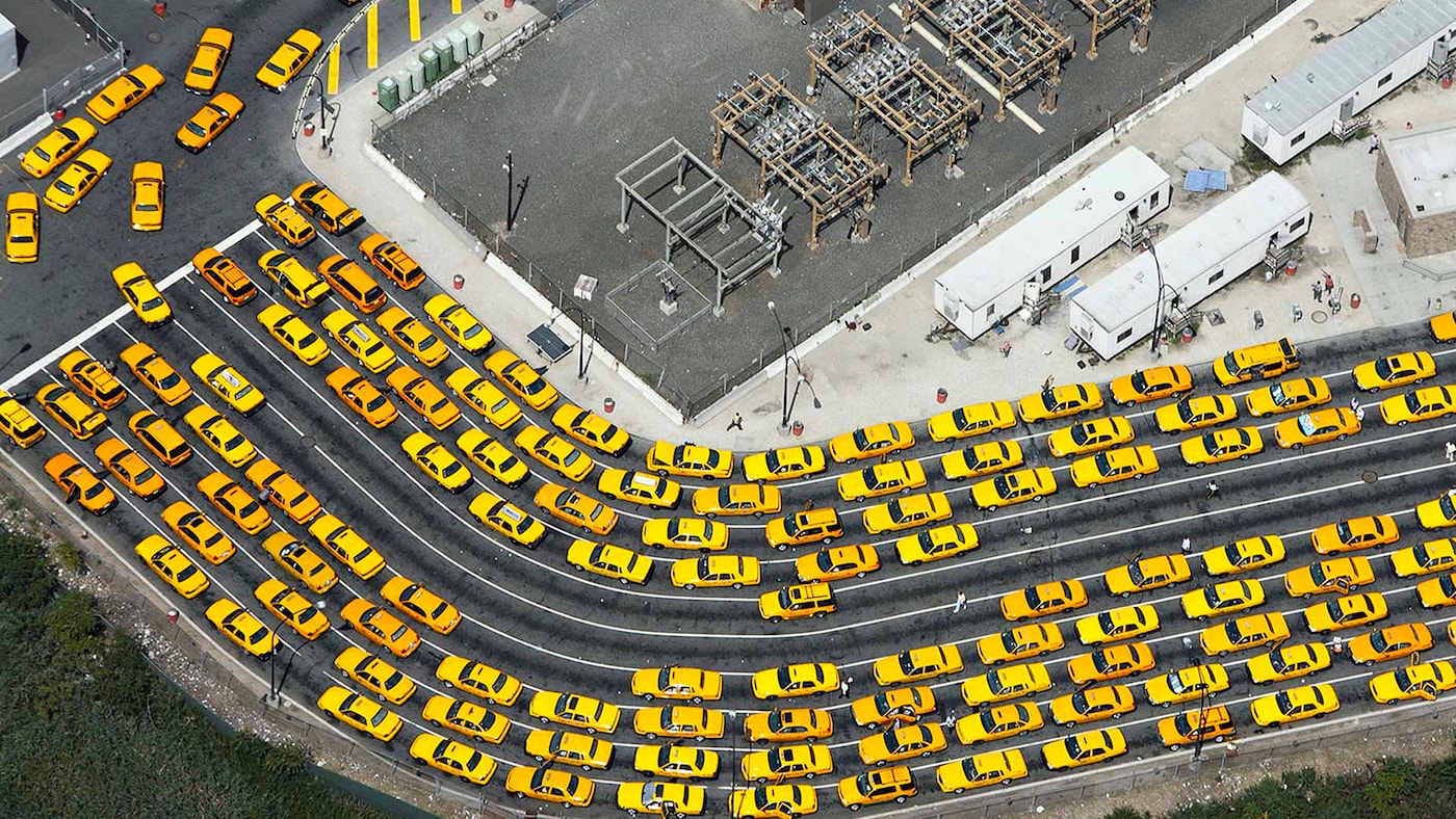 Vibrant yellow taxis stand out from grey surroundings.