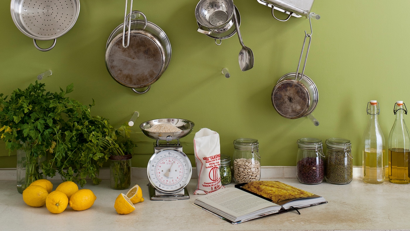 Pots and pans against a soft green kitchen wall.