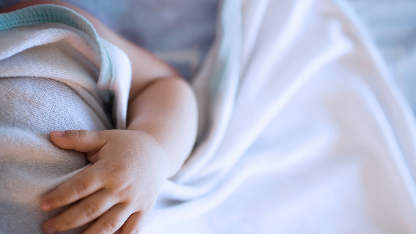 Peaceful baby sleeping in a blue room.