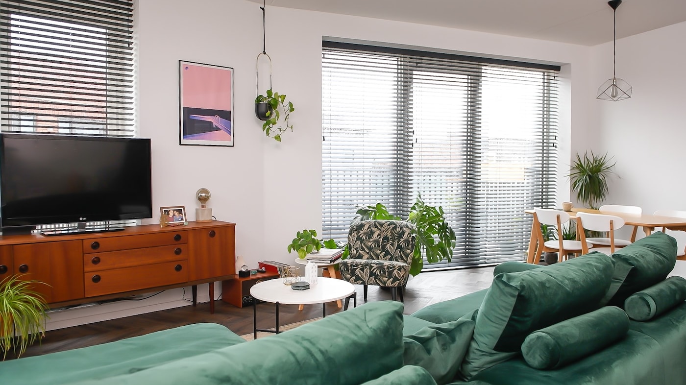 De harde witte muren maken de woonkamer kil en weinig sfeervol