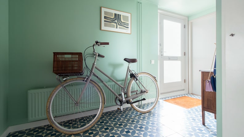 Fiets in de gang tegen een mintgroene muur