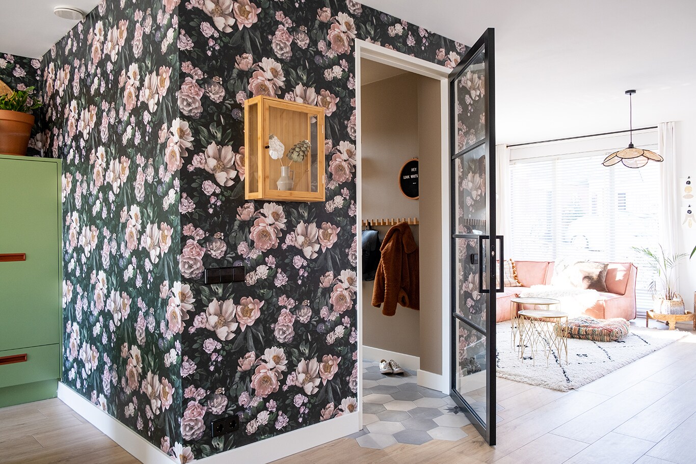 Een kijkje in de hal geschilderd in de trendkleur Brave Ground™ met bloemenbehang op de voorgrond