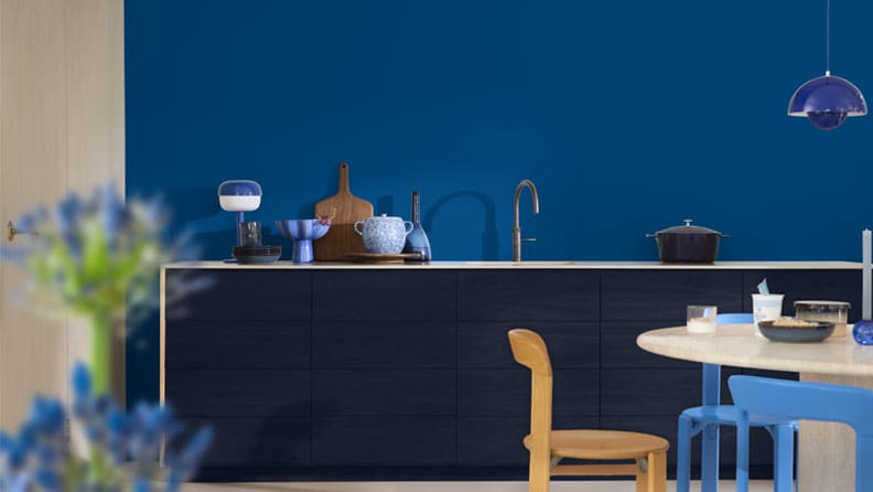 Een blauwe keuken met de kleuren Free Groove op de muur en Slow Swing op de kastjes