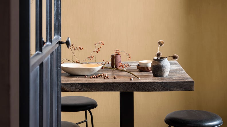 Landelijke eetkamer  met de kleur Wild Wonder op de muur