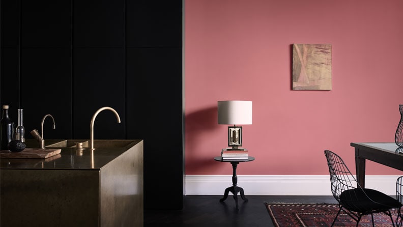 Warme en elegante keuken met de kleur Vol Appel op de muur