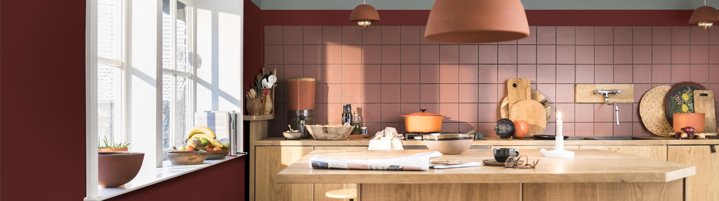 Keuken met warme rode kleur Puur Rabarber op de muur