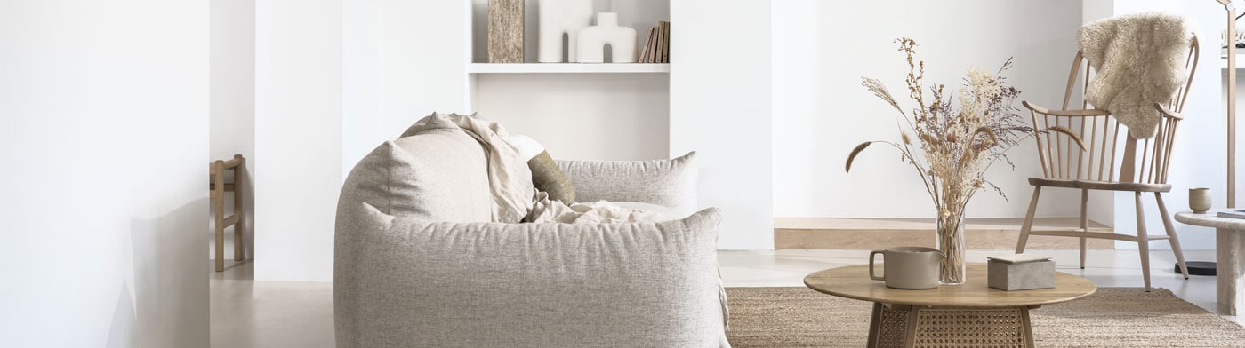 Witte woonkamer met grijze bank en houten salontafel