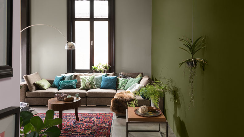 een bohemian woonkamer met muren in de kleuren Midden Natuursteen en 100% Laurier