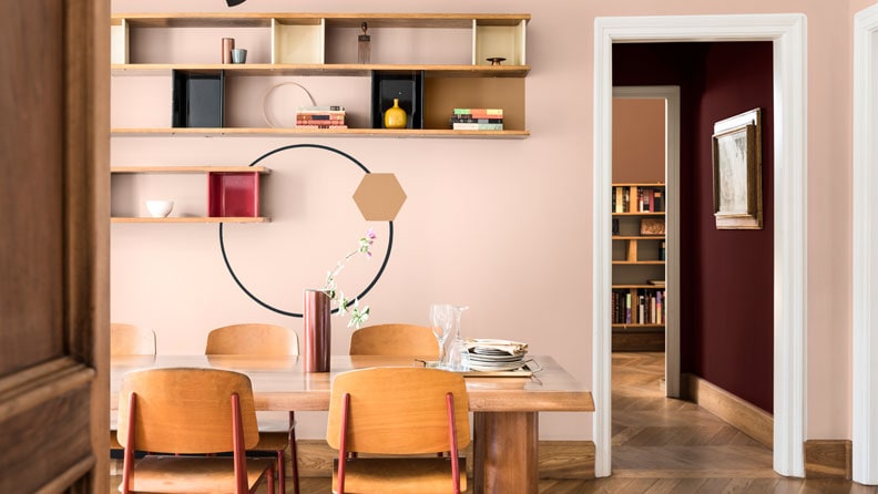 een eetkamer met vintage stoelen en muren in de kleuren Schemerroze en Joyful Ruby