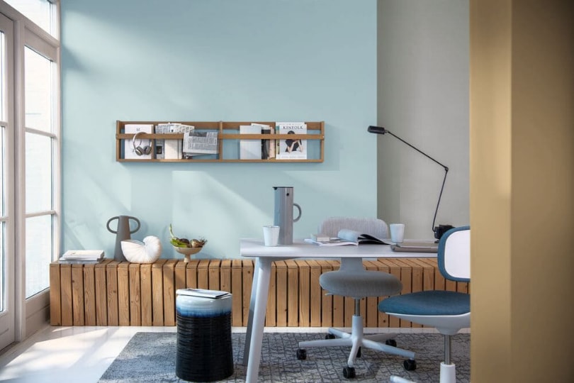 home office con la pared pintada en azul claro, combinado con detalles en gris y verde