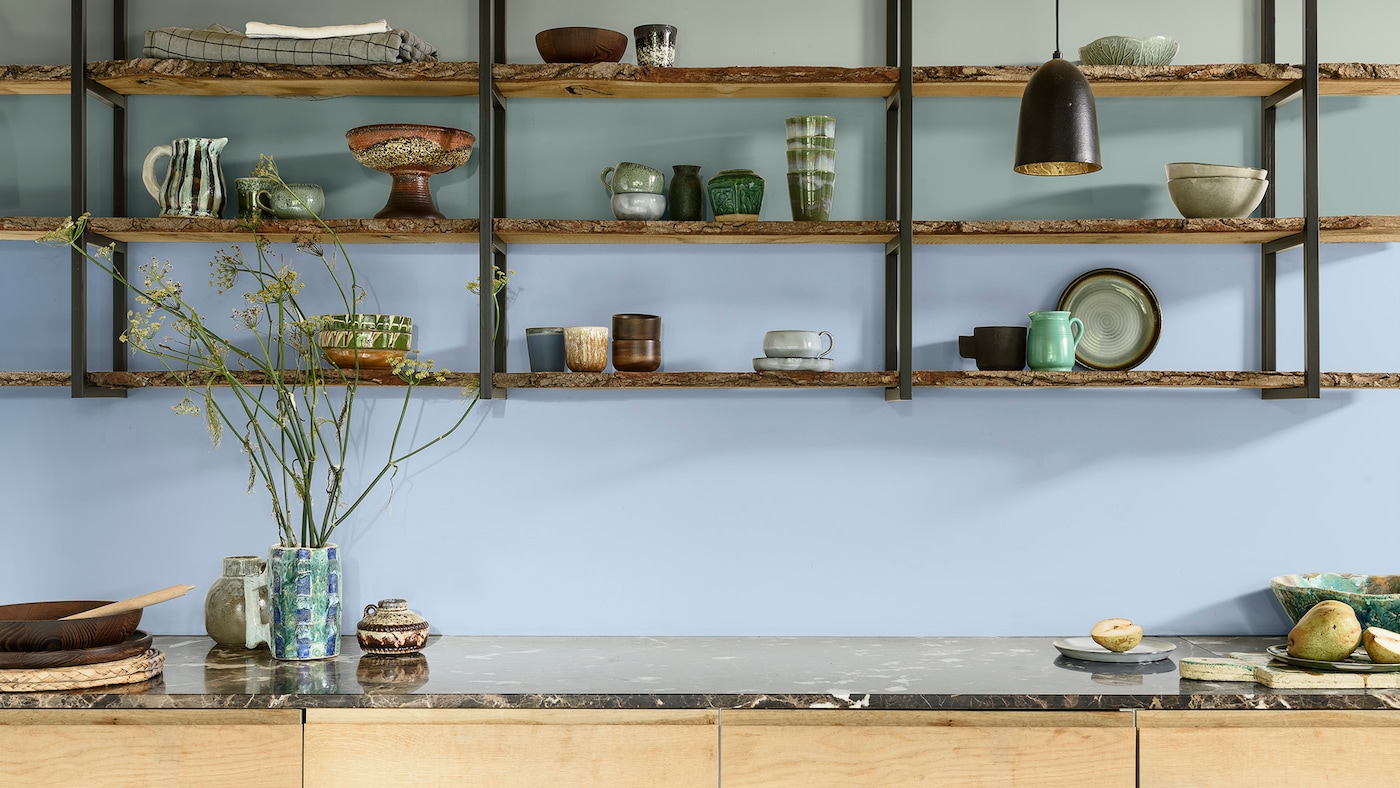 Cuisine avec étagères ouvertes avec mur du fond bleu et vert