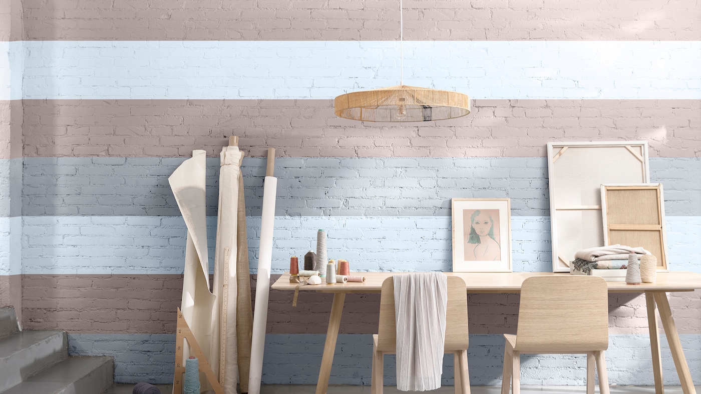 Bureau, sièges et toiles contre un mur à rayures de couleur neutre