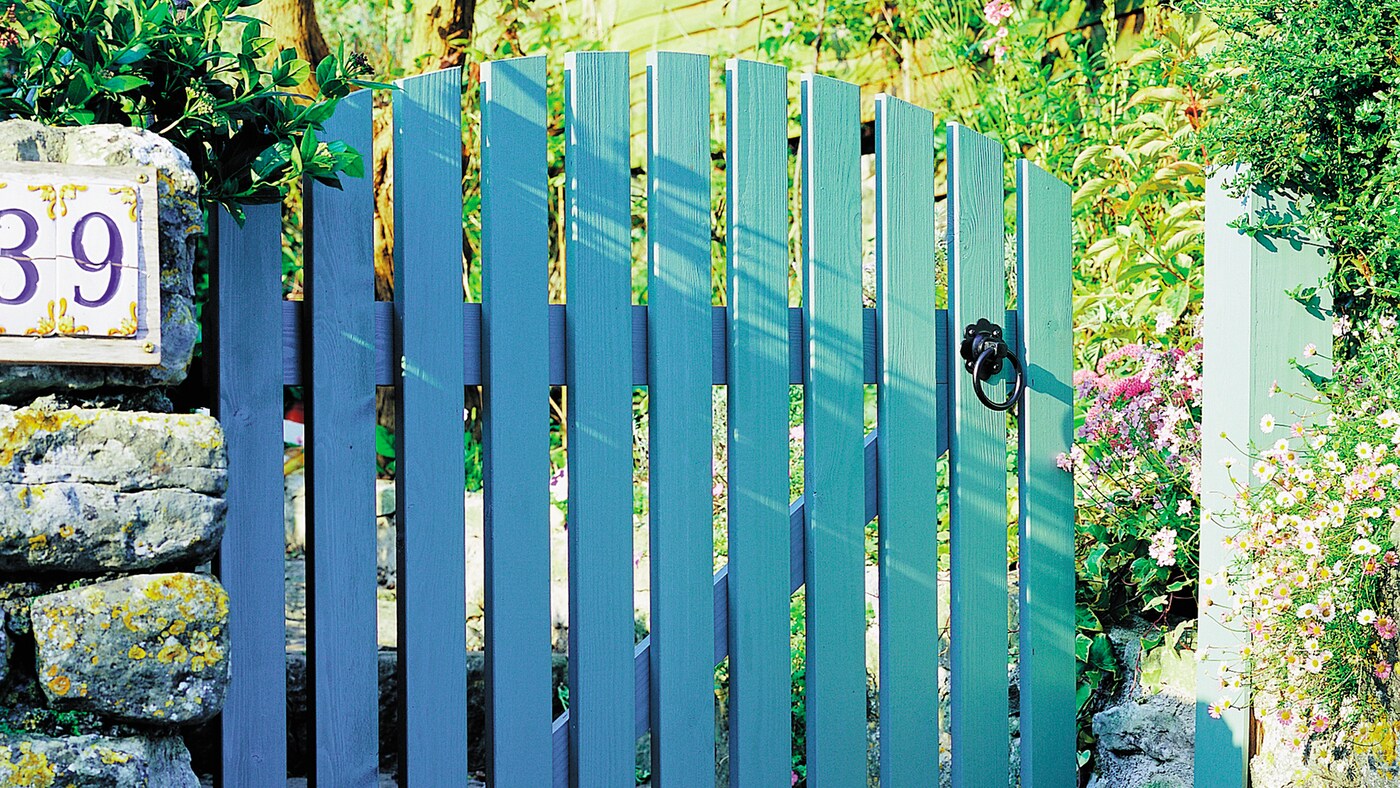 Geverfd houten hek vrolijkt de ingang naar je huis op