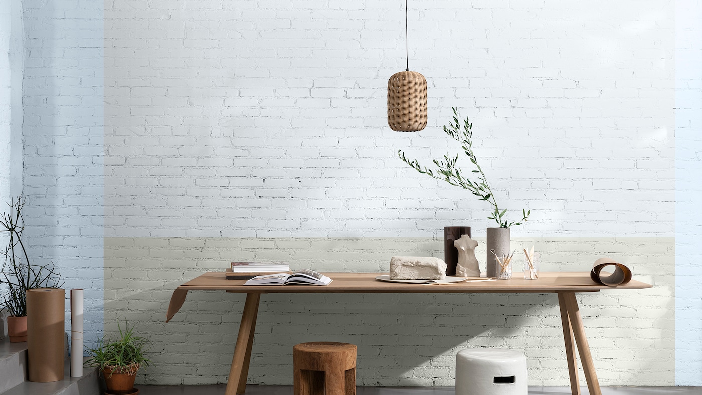 Bureau tegen lichtgroene bakstenen muur met blauwe rand