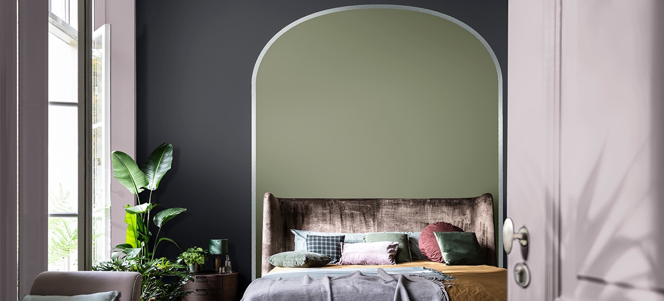 slaapkamer met groene boog achter het bed