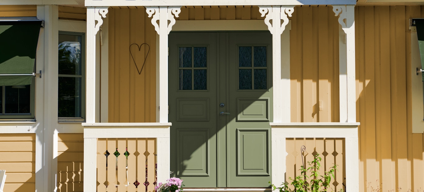 Inngangsdøren er malt i lys grå