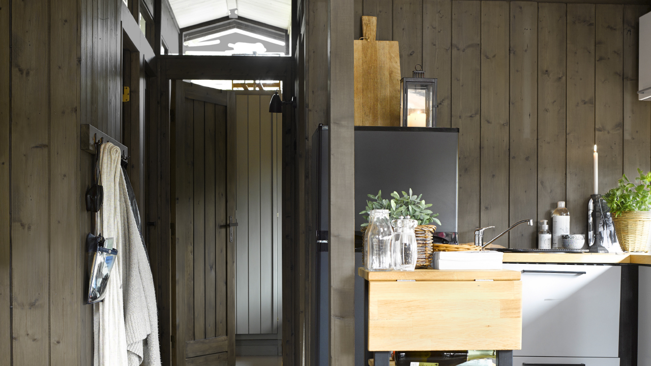 Mørke vegger og lyse gulv og tak på hytta