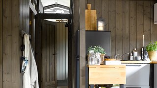 Mørke vegger og lyse gulv og tak på hytta