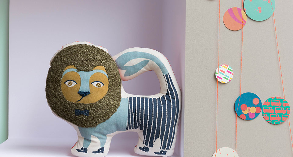 Λούτρινο κουκλάκι πάνω σε μωβ ράφι