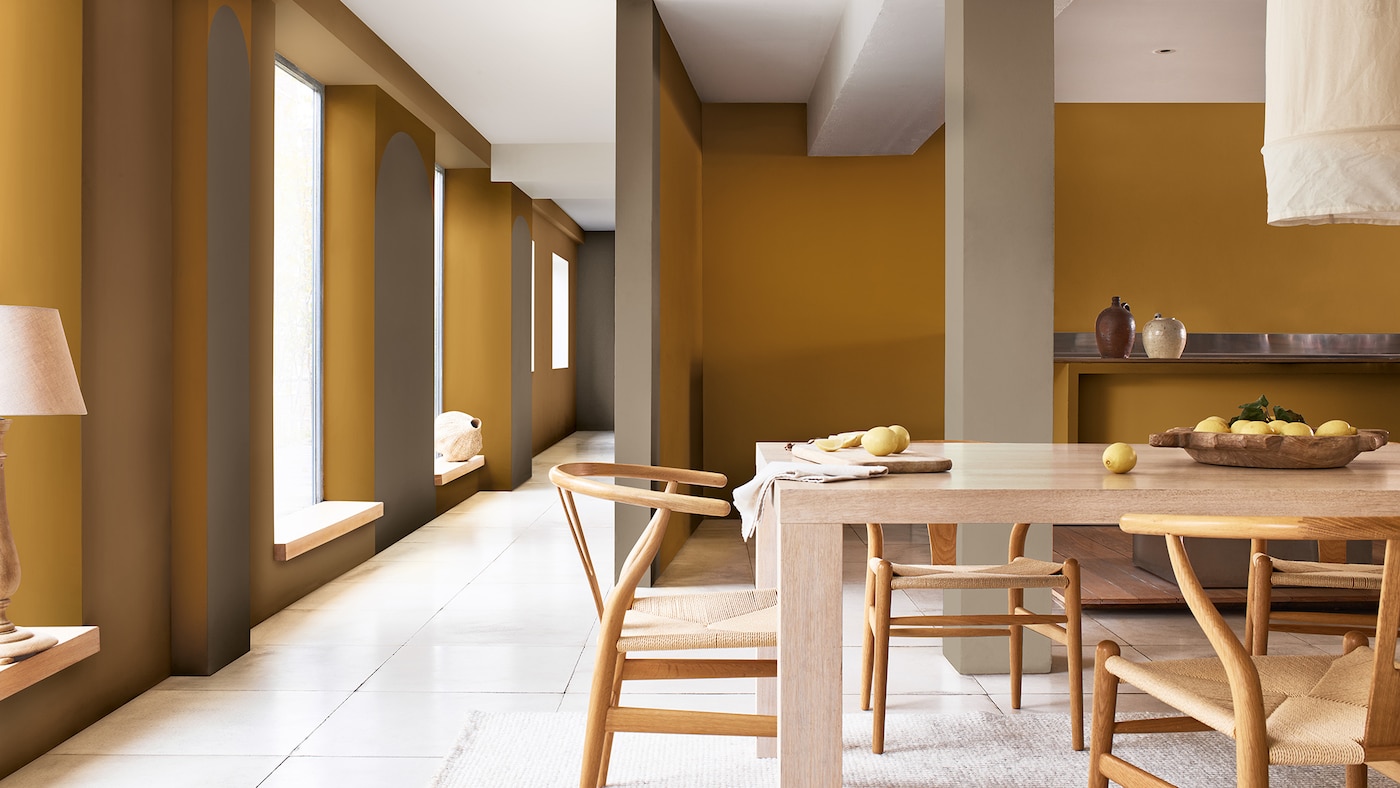 Open plan dining room with wooden table and tall windows on left-hand side