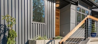 Treppenaufgang zu Haus mit Metallfassade in Grau