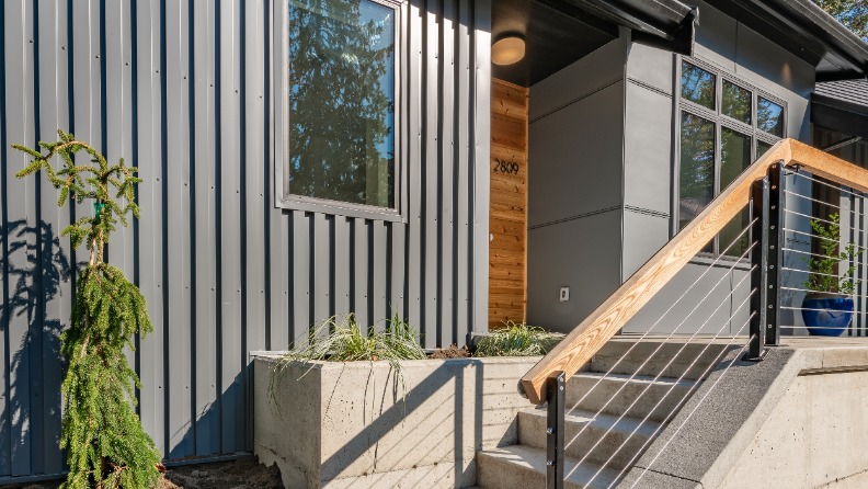 Treppenaufgang zu Haus mit Metallfassade in Grau