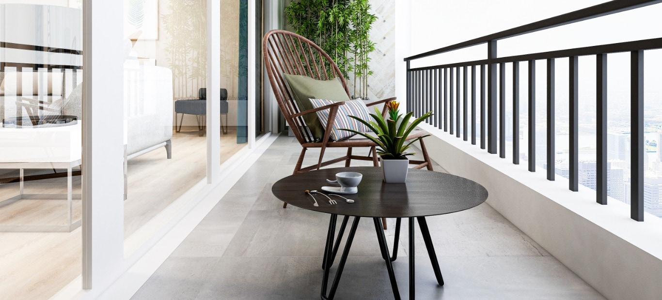 Ein schwarzes Metallgeländer an einem Balkon mit Stuhl und Tisch