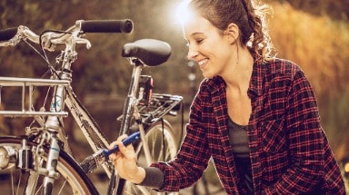 Eine Frau streicht einen Fahrradrahmen mit dem Metall-Schutzlack Ultima von Hammerite.